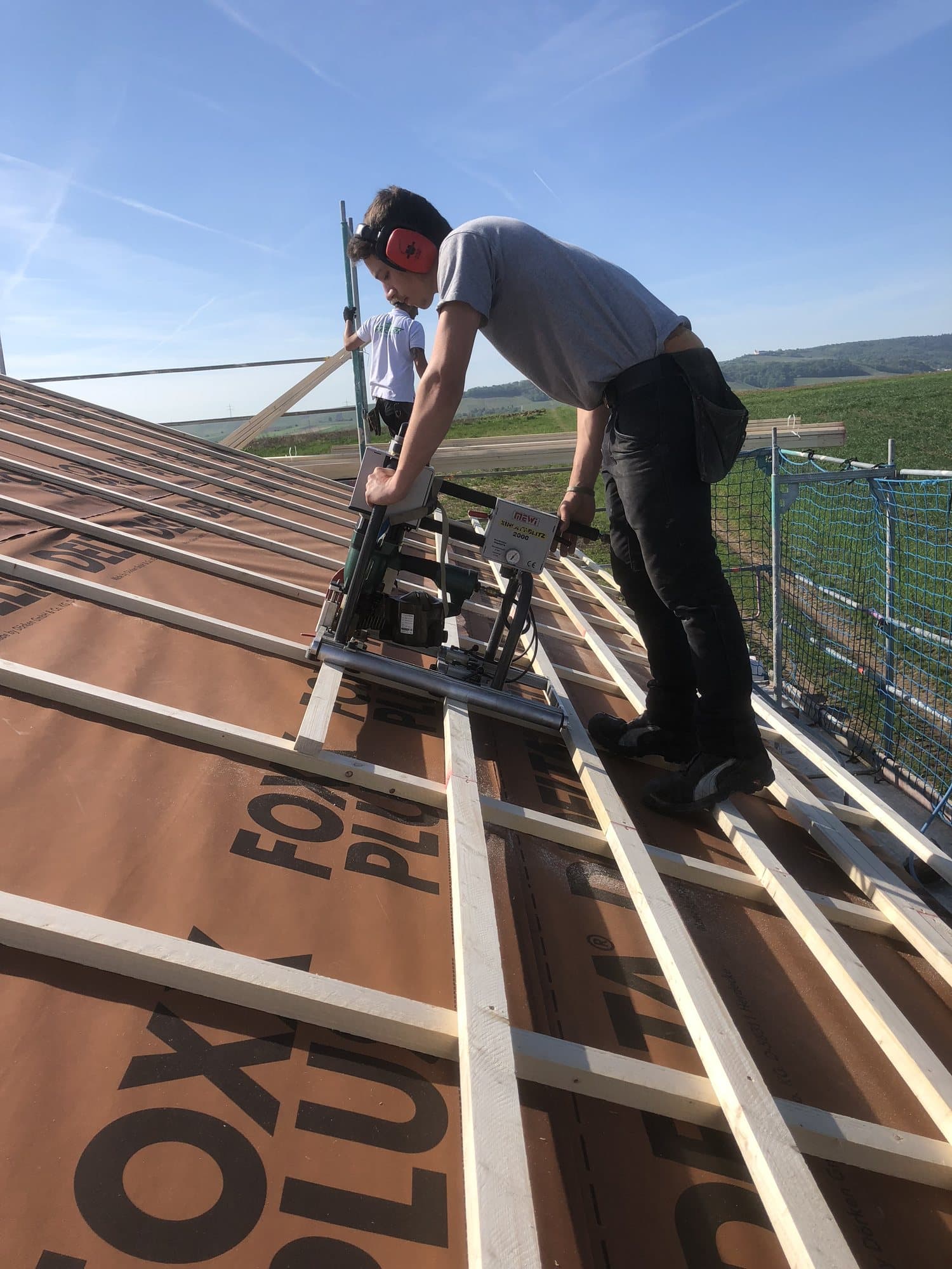 Zimmerer von Heckler Holzbau bei der Dachlattung auf dem Dach
