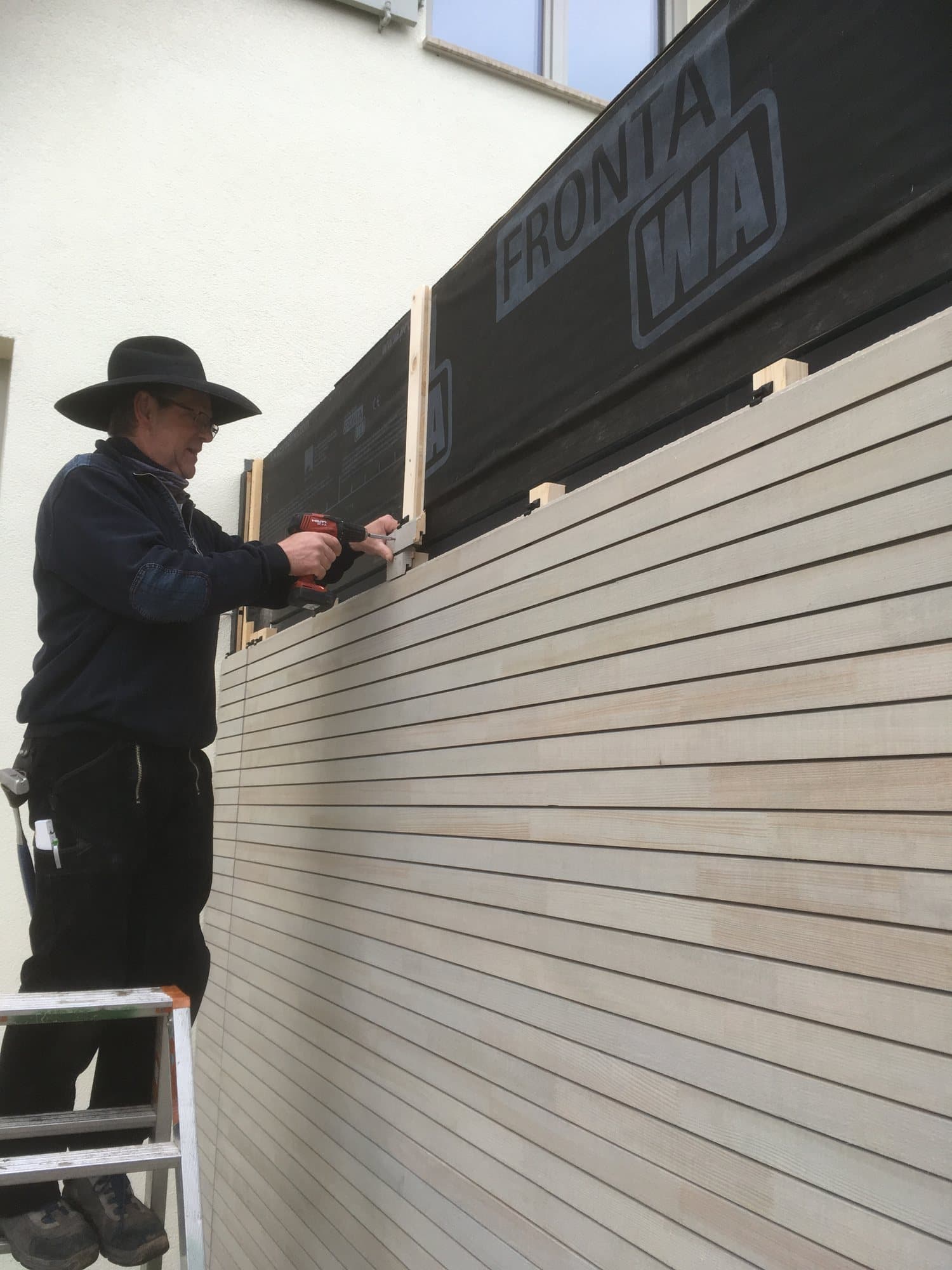 Zimmerer von Heckler Holzbau bei der Montage einer Holzfassade